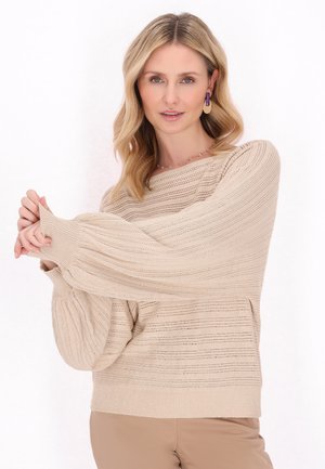 Beżowy sweter dzianinowy z teksturowanym paskowanym wzorem, szerokimi rękawami i luźnym krojem, z okrągłym dekoltem i prążkowanym dolnym wykończeniem.