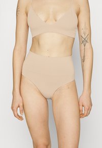 Beige ribbed bralette ja korkeat vyötäröalushousut, joissa on sileä pinta ja minimalistinen muotoilu, sopii arkipukeutumiseen.