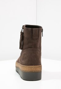 Brązowe zamszowe botki za kostkę o teksturowanym wykończeniu, gumowa podeszwa, zamek błyskawiczny oraz dekoracyjny chwost z boku. Podeszwa platforma dla dodatkowej wysokości.