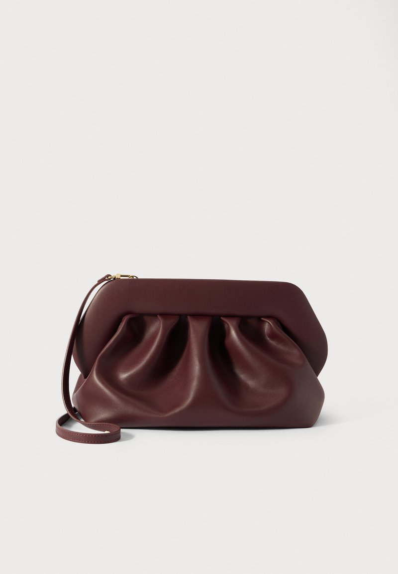 Pochette en cuir bordeaux avec un design plissé, texture lisse et un cadre rectangulaire. Dispose d'une courte sangle et d'une fermeture éclair dorée.