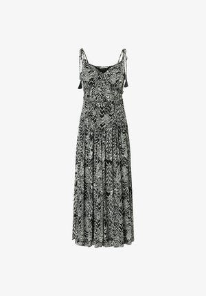 Zwart-witte mouwloze maxi-jurk met abstract zigzagpatroon en bindbandjes met kwastjes op de schouders.