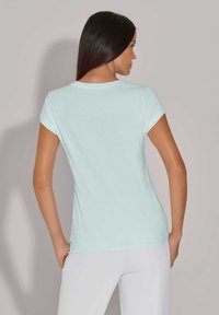 Lichtblauw T-shirt met korte mouwen, ronde hals, zachte textuur en slim fit, met een gladde afwerking zonder zichtbare patronen of details.