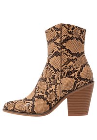 Tan snake print ankle boot with a pointed toe and textured finish. Features a stacked heel and angular silhouette. Robust construction.