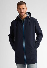 Granatowa wodoodporna kurtka z zamkiem błyskawicznym z przodu, niebieskimi akcentami, kapturem ze sznurkiem i dwiema bocznymi kieszeniami. Gładka tekstura i długi krój.