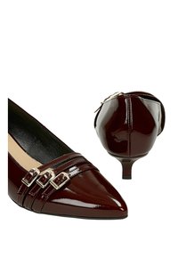 Scarpe con tacco in pelle verniciata color bordeaux con punta affusolata, design a tre cinghie con fibbie metalliche e tacco sottile.