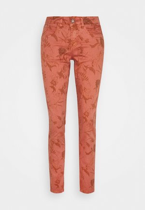 Spodnie o wąskim kroju w kolorze rdzy z delikatnym wzorem kwiatowym, z przodu guziki i detale kieszeni na jednolitym białym tle.