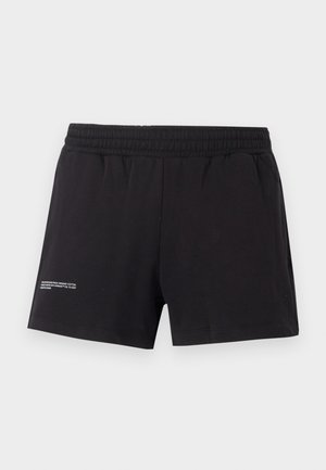 Shorts noirs en coton biologique avec une taille élastique, des poches latérales et une petite étiquette imprimée sur le bas à gauche.