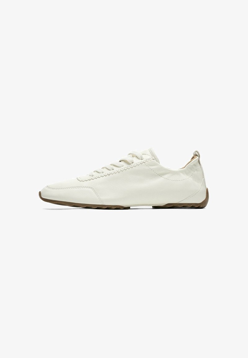 White low-top casual sneaker with laces and a brown rubber sole, shown from the outer side on a white background.