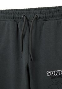 Donkergrijze joggers met een elastische tailleband met trekkoord, een zachte textuur en geborduurd "SONIC" logo met graphics op het been.