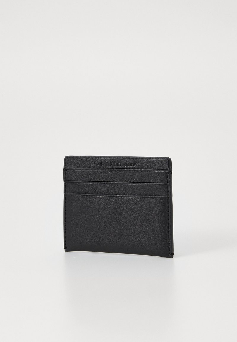 Portafoglio in pelle nera con quattro tasche frontali, logo embossato in alto e superficie liscia. Forma rettangolare compatta, design minimalista.