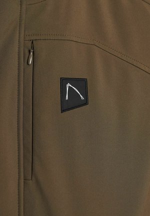 Olive green jacket featuring a zippered chest pocket and a black patch with a white geometric design. Smooth fabric with a matte finish.
