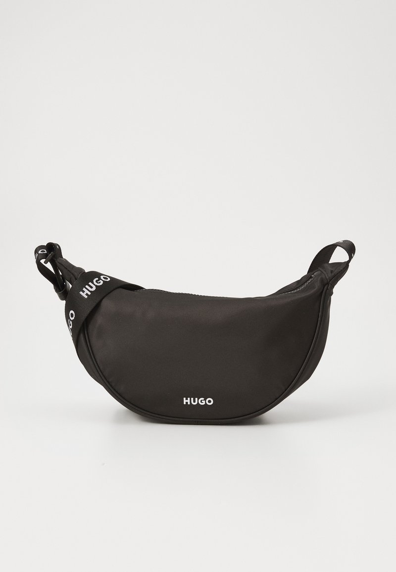 Černá nylonová taška přes pás s oblým tvarem, zdobená bílým logem "HUGO" a nastavitelného popruhu pro různé možnosti nošení.