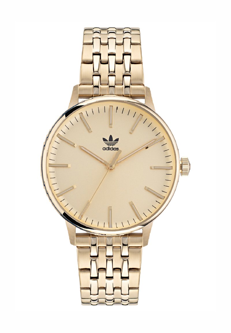 Montre-bracelet dorée avec un cadran beige, marqueurs d'heure fins et un bracelet en métal texturé. Comprend un logo à 12 heures et une couronne.
