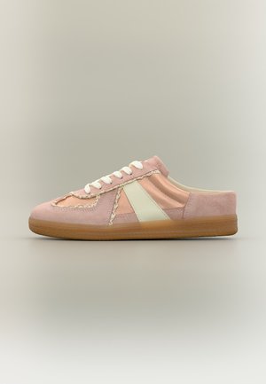Baskets en daim et tissu rose avec lacets blancs, détail latéral blanc et semelle en caoutchouc marron, vues de côté sur un fond neutre.