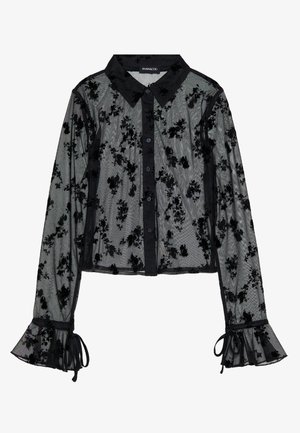Svart gjennomsiktig bluse med blomstermønster, knappelukking, krage og flagrende ermer. Laget av delikat stoff med teksturerte detaljer.
