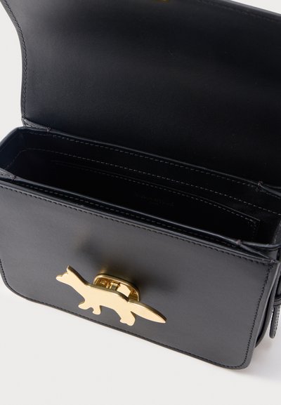 Ανοιχτή μαύρη δερμάτινη τσάντα ώμου με χρυσό κούμπωμα σε σχήμα αλιγάτορα και ραμμένες εσωτερικές θήκες.