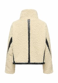Veste en polaire texturée de couleur crème avec un col montant, des panneaux d'accent noirs et une coupe courte. Elle présente une coupe droite et des manches longues.