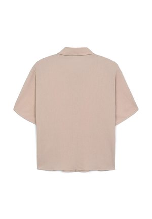 Chemise oversize à manches courtes en tissu beige clair avec une texture subtile, dotée d'un col classique et d'un ourlet droit.