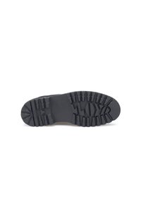 Semelle de chaussure en caoutchouc noir avec des crans profonds et une texture striée. Présente un profil plat avec un marquage en relief de la marque au centre.