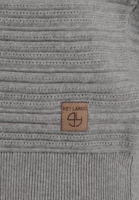Pull en maille gris avec des rayures horizontales texturées. Doté d'une étiquette en cuir marron avec le logo "KEY LARGO" dans le coin inférieur droit.
