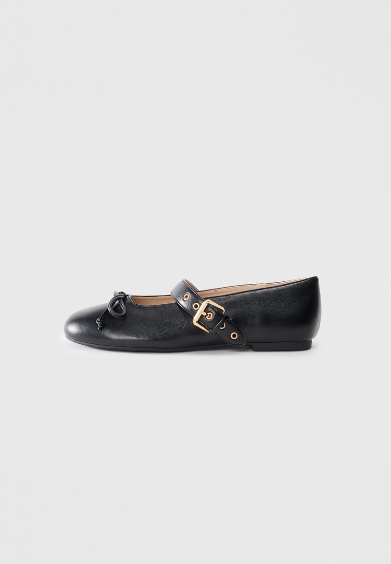 Zwarte leren platte schoen met een ronde neus, verstelbare band en goudkleurige gespsdetails. Gladde textuur en minimalistisch ontwerp.