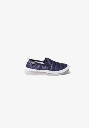 Granatowe, pikowane buty typu slip-on z białą, teksturowaną podeszwą i wyściółką w środku, z małą metką logo po boku.