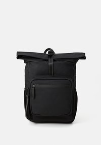 Sac à dos noir à rouleau avec poche zippée à l'avant, poches en mesh sur les côtés et une sangle à boucle centrale sur un fond blanc.