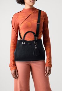 Sort tekstureret håndtaske med dobbelte top-håndtag, sølv hardware og en aftagelig charm, suppleret med en lang sort rem.