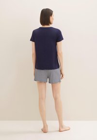 Haut à manches courtes bleu marine avec un col rond, associé à un short rayé bleu clair et blanc, offrant une coupe décontractée et un tissu doux.