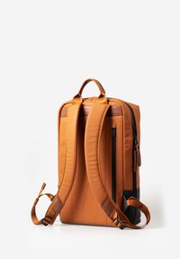 Oranje rugzak met gevoerde schouderbanden, een handvat aan de bovenkant en een ritsvak aan de voorkant; heeft een gladde textuur en zwarte accenten.