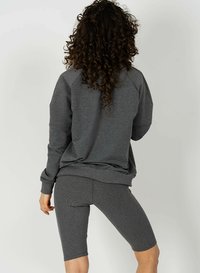 Szary sweatshirt z raglanowymi rękawami, połączony z fakturowanymi szarymi szortami. Materiał wydaje się miękki, o unikalnym żebrowanym wzorze.