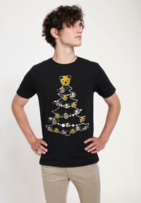 Svart bomulls t-shirt med ett björnar och panda-träd design i vitt och ljusa färger, med lekfulla ansiktsdetaljer och cirkulära ornament.