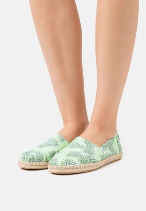 Espadrilles verdes de tela com um padrão de folha de palmeira, apresentando uma sola de juta trançada e design slip-on. Textura suave com um acabamento leve e respirável.