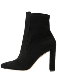 Bottine en daim noir avec bout pointu, silhouette élégante, talon stiletto haut et détails de couture minimalistes.