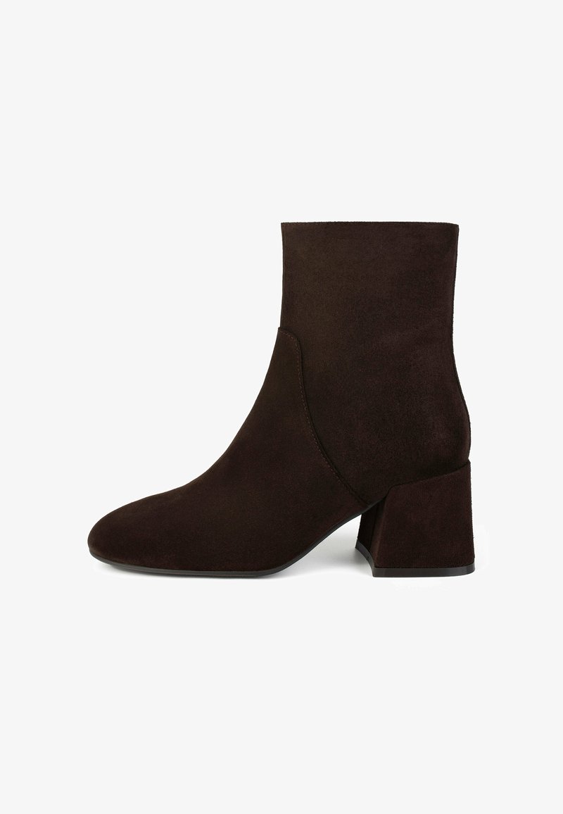 Stivale alla caviglia in suede marrone con punta appuntita e tacco a blocco. Texture liscia, design minimalista, senza hardware visibile o decorazioni.