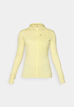 Light yellow zip-up jacket with long sleeves and a hood. Features a fitted design and textured fabric, ideal for layering in various activities.