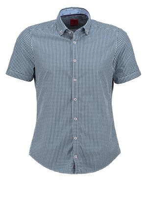 Homme portant une veste en cuir marron, une chemise à carreaux bleue, un pantalon gris clair et des chaussures en cuir marron, debout avec une main dans la poche.