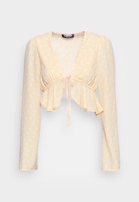Top cropped amarelo com estampa floral, mangas longas, corpete franzido e barra com babados. Possui um fecho em laço na frente e uma textura de tecido suave.