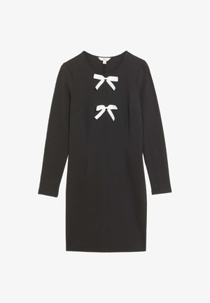 Robe noire à manches longues avec un col rond, ornée de deux nœuds blancs à l'avant. Fabriquée dans un tissu lisse avec une coupe structurée.