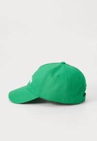 Cappello verde in cotone con visiera curva, con logo bianco sulla parte anteriore. Presenta una finitura testurizzata e una cinghia regolabile sul retro.