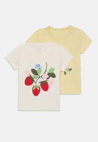 Två kortärmade t-shirts: en vit med röda jordgubbar och blommor; en enfärgad gul. Båda är gjorda av mjuk bomull.