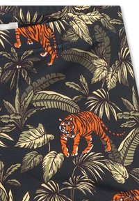 Schwarzer Stoff mit einem lebhaften Tigermuster zwischen grünen tropischen Blättern. Das Design hebt kräftige orangefarbene Tigerstreifen und detailliertes Laub hervor.