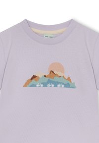 Hellblaues Baumwoll-T-Shirt mit einem Grafikdesign von Bergen und einer Sonne in erdigen Tönen, mit drei Fahrrädern am Boden.
