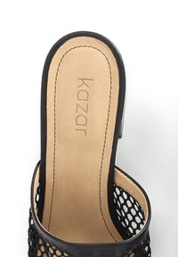 Černá síťová slip-on obuv s hladkým koženým interiérem a zaobleným zadním dílem. Šití podél okrajů a viditelné logo značky.