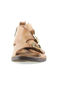 Sandale en cuir fauve à bout ouvert, avec deux brides à boucles dorées sur le devant et une semelle plate, vue de face.