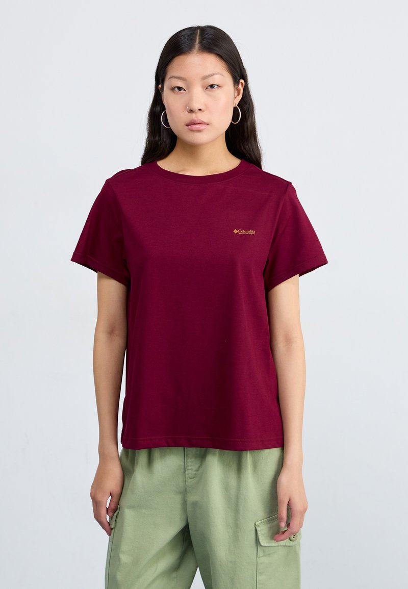 Maroonowa bawełniana koszulka z krótkim rękawem, okrągłym dekoltem i małym złotym logo po lewej stronie klatki piersiowej. Miękka tekstura i luźny krój.