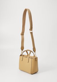 Petit sac à main rectangulaire en matière synthétique beige, avec deux poignées supérieures, une sangle amovible et des accents en métal doré.