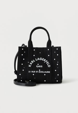 Sac tote noir Karl Lagerfeld avec détails en clous blancs, doubles poignées, bandoulière amovible et texte "Paris 21 Rue St-Guillaume" sur le devant.