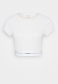 Vit mjuk bomullsy cropped topp med korta ärmar, rund halsringning och ett kontrasterande midjeband med grå ränder och en logotyp. Mjuk textur.