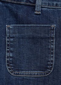 Tummansininen farkkukangas, jossa on silmiinpistävä takatasku, vahvistettu tikkaukseen vaaleammassa värissä. Tasku on suorakulmaisen muotoinen ja sileä tekstuuri.